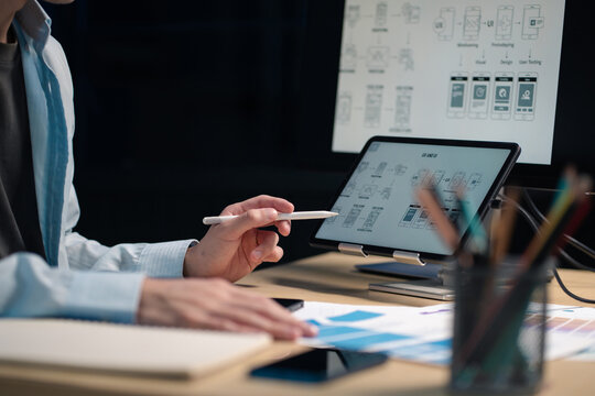 Male coder or developer working overtime using a computer display in problem solving at workplace.
