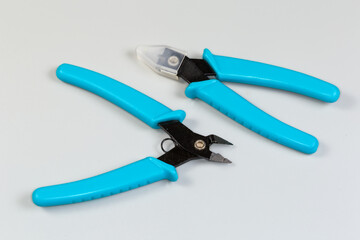 Obraz premium Two diagonal nippers with blue insulated handles on gray background