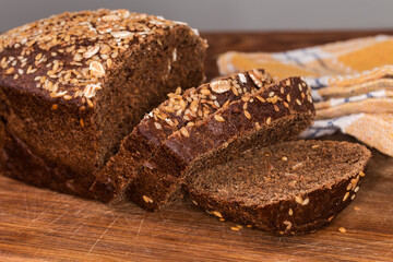Partially sliced grain brown bread, close-up in selective focus