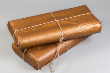 Flat items wrapped in wax paper and tied with ropes