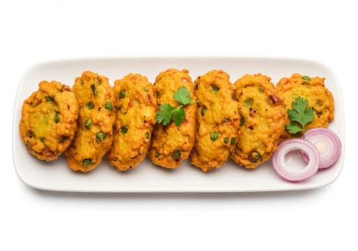 Delicious and crispy vada served on a plate, garnished with herbs and onions
