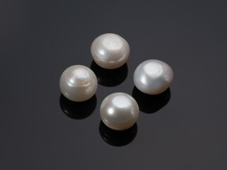 Four Iridescent Natural Pearls on Black Background, Close-up Jewelry Stones, Pearl Luster, Luxury...