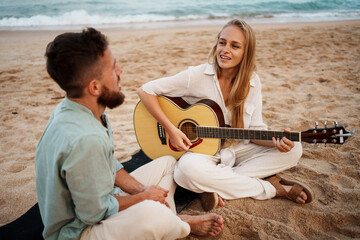 A Couple Enjoying Beautiful Music Together on the Beach During a Stunning Sunset