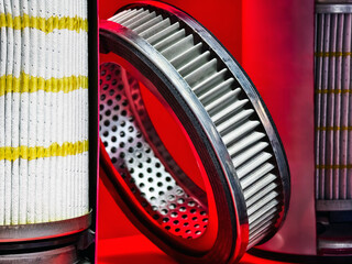 Artistic display of automotive filters showcasing intricate designs and textures in a vibrant red backdrop