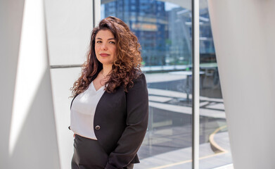 Elegant Brunette Woman in Business Attire Standing Outside Office