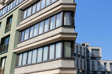 Modern corner balcony with unusual geometric shape on a high-rise residential building, glass railings, contemporary architecture