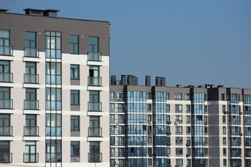 Modern residential high-rise buildings with windows and blue sky, urban architecture, clean facade, geometric lines, cityscape