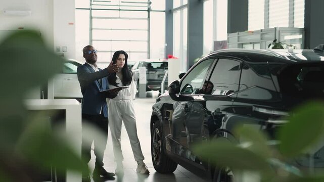 A customer at a car dealership consults with a salesperson, choosing a new vehicle. Concept: a trusting dialogue between the buyer and the consultant, the decision-making process for purchasing a car.