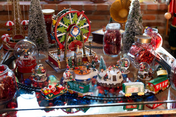 Christmas village with santa claus, carousel, train, ferris wheel, and snow globes decorating a glass table