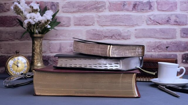 Bible falling for study on gray table with glasses clock and coffee in the morning. Preparation for communion and worship concept. Slow motion