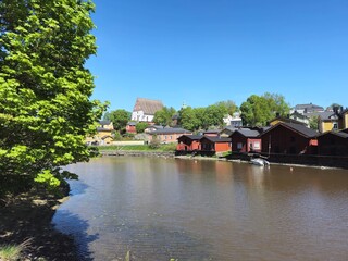 Obraz premium Old wooden houses, river and Porvoo Cathedral on a sunny day