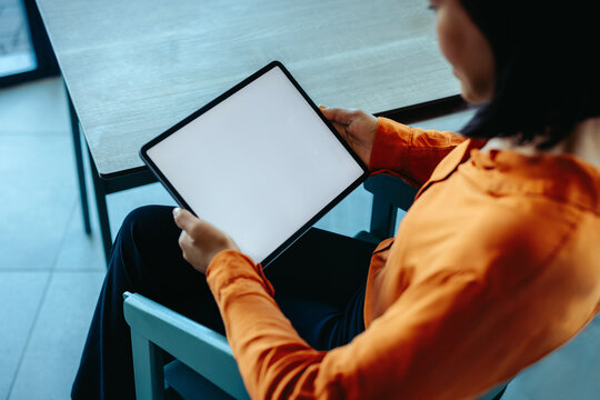Businesswoman using a tablet in modern office setting - Powered by Adobe