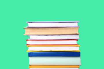 Stack of colorful books on green background