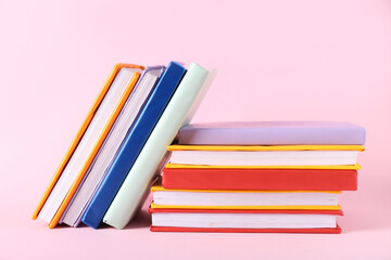 Many colorful books on pink background