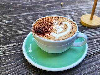 Close up of a cappuccino with on a timber table.