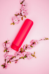 Shampoo, hair conditioner in a red jar on a pink background. Mockup, space for text. Sakura...