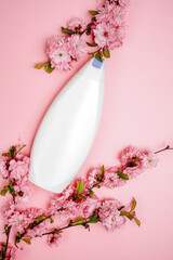 Shampoo, hair conditioner in a white jar on a pink background. Mockup, space for text. Sakura...