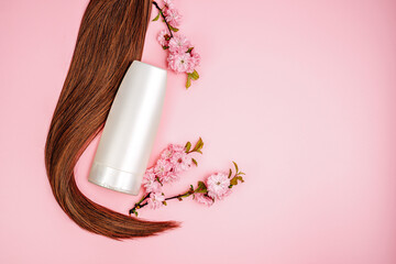Shampoo, hair conditioner in a white jar on a pink background. Mockup, space for text. Sakura...