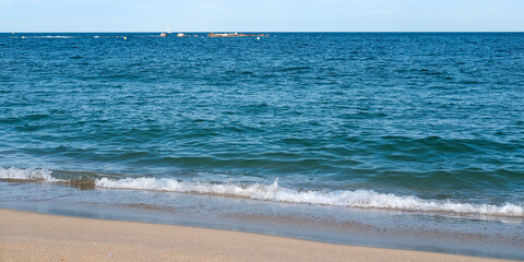 Tranquil beach scene with gentle waves lapping against the sandy shore, showcasing the serene beauty of nature and inviting relaxation and peace in a coastal environment. Banner with copy space