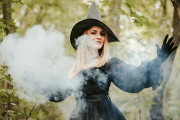 girl in a fluffy black dress conjures smoke in the forest, halloween