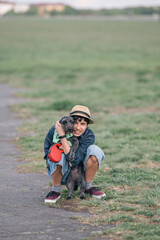 Teenager girl hugging dog in a park during an outdoor activity