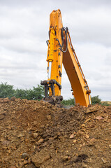 Industrial Power: The Machine's Arm Peeking Over the Mound.
