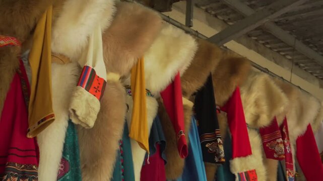 Traditional fur garments adorned with colorful woven patterns, hanging in a rustic village near Sapa, North Vietnam. Ideal for concepts of heritage, culture, and craftsmanship.