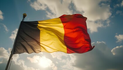Belgian flag waving against a cloudy sky during the evening, showcasing vibrant colors of black, yellow, and red in a beautiful natural setting Generative AI