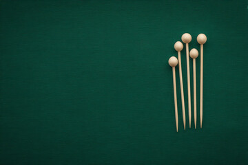 Crafted wooden cocktail sticks gather ceremoniously like ancient sentinels, poised for World Cocktail Day, evoking mid-century mixology rituals