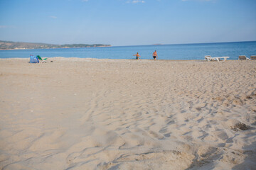 Obraz premium Serene beach with soft sand, clear sky, and gentle waves—perfect for travel ads, wellness blogs, and summer lifestyle campaigns.