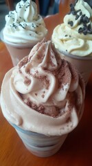 Close-up of Creamy Dessert Parfaits with Various Toppings on a Wooden Surface