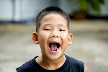 A laughing little boy's adorable face shows his open mouth and smiling eyes, a portrait of childhood joy