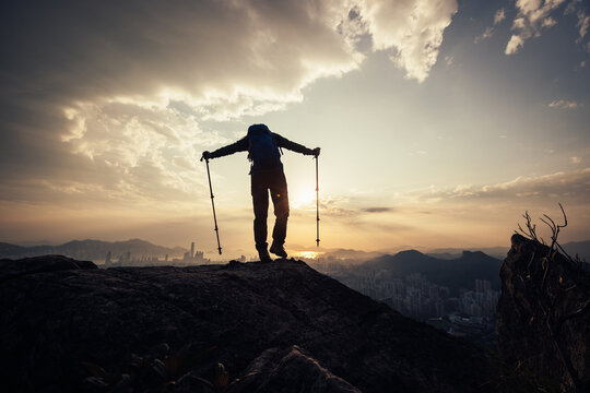 Successful backpacker enjoy the view stand on the cliff edge in hong kong