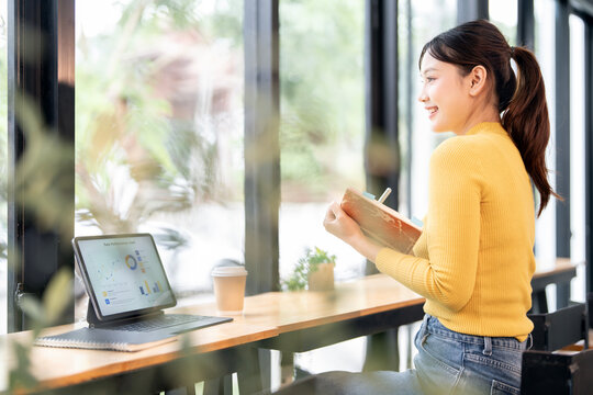 Creative young woman working on laptop, sitting at co workspace or cafes