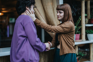 A young couple shares a warm and intimate moment while holding hands at a cozy cafe. The ambient setting enhances the emotional connection and affectionate atmosphere between them.