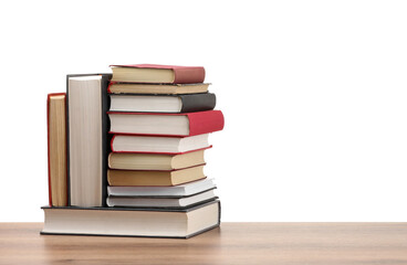 Many old books on wooden table against white background