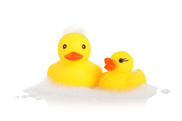 Cute rubber ducks and foam on mirror surface against white background