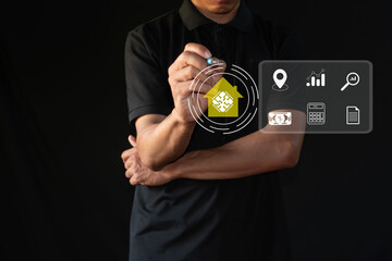Man points pen at modern digital interface displaying real estate elements on virtual screen.