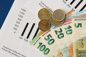 European union Euro money bills and coins with european electricity utility bill on table