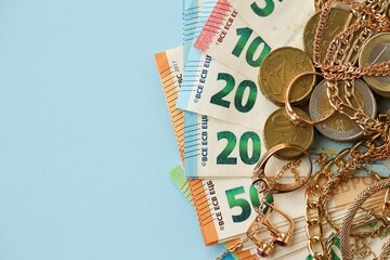 European union Euro money bills and coins with golden rings and jewelry necklaces on blue table