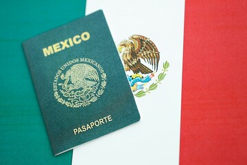Mexican passport lies on Mexico flag close up. Travel and citizenship