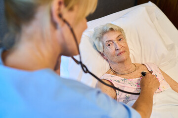 Nurse providing care to an elderly woman in a medical setting