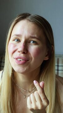 Young woman makes a Gen Z finger heart gesture and says "I love you" with a warm smile. Cute and affectionate expression