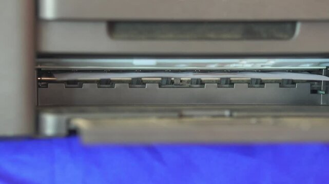 Footage of a printer printing paper, Closeup of a printer in operation, Office equipment. Technology work business, communication, meeting and note.