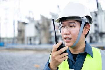 Engineer is working at high voltage power substation performing inspection and check of...