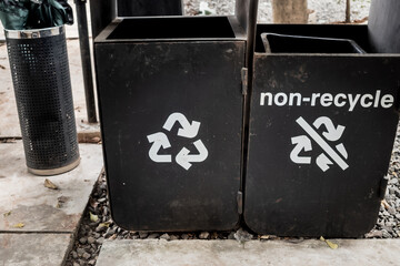 Black trash containers for recyclable and non-recyclable wastes at outdoor public area