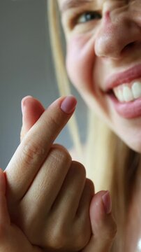 Young Gen Z girl showing a finger heart gesture with a sweet smile. Close-up portrait.