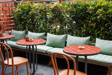 Elegant outdoor seating area with greenery at a restaurant during midday