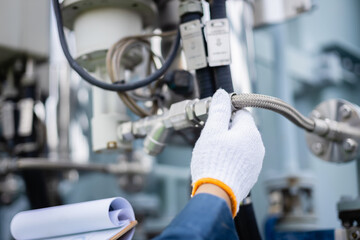 Engineer is working on high voltage power substation performing inspection and check of...