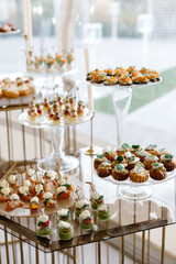 Catering service presenting delicious appetizers on glass stands